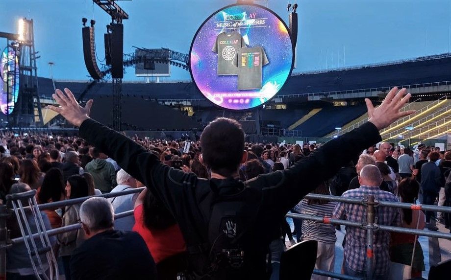 Persona con mochila vibratoria disfruta de un momento del concierto de Coldplay